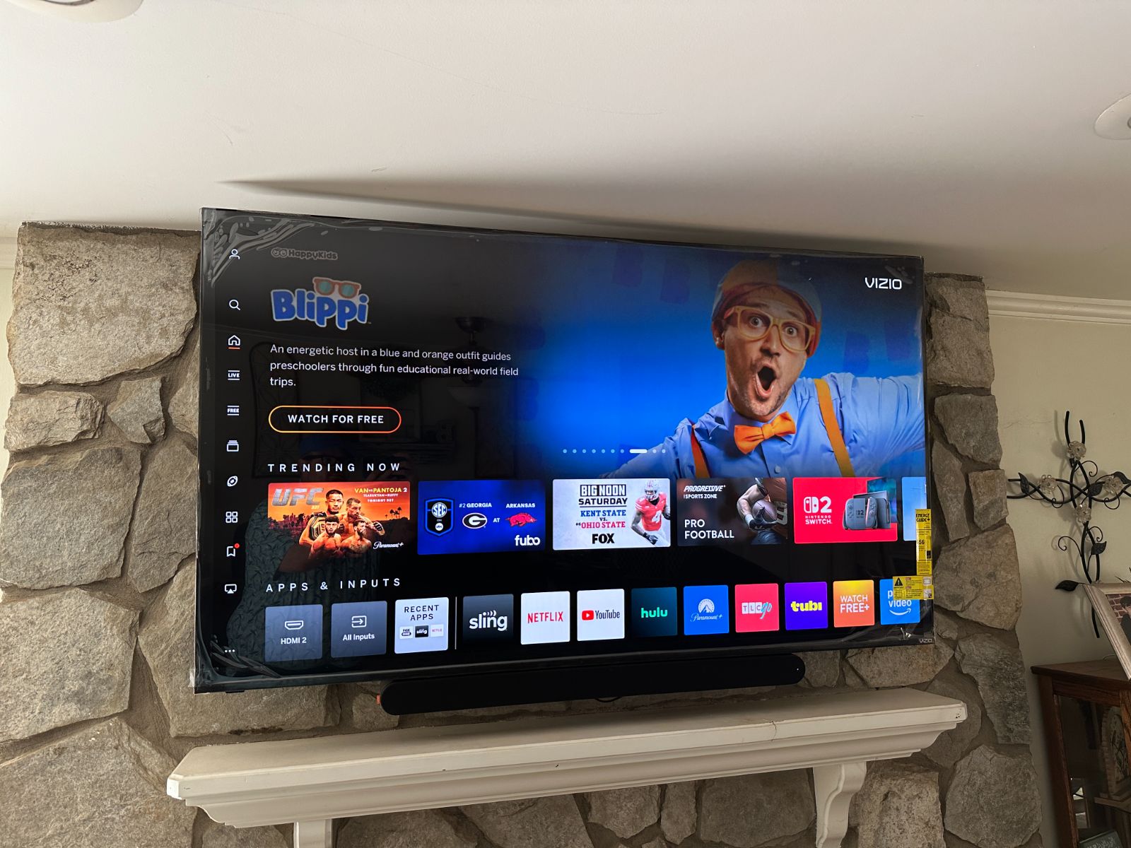 Repaired wall-mounted TV over a stone fireplace